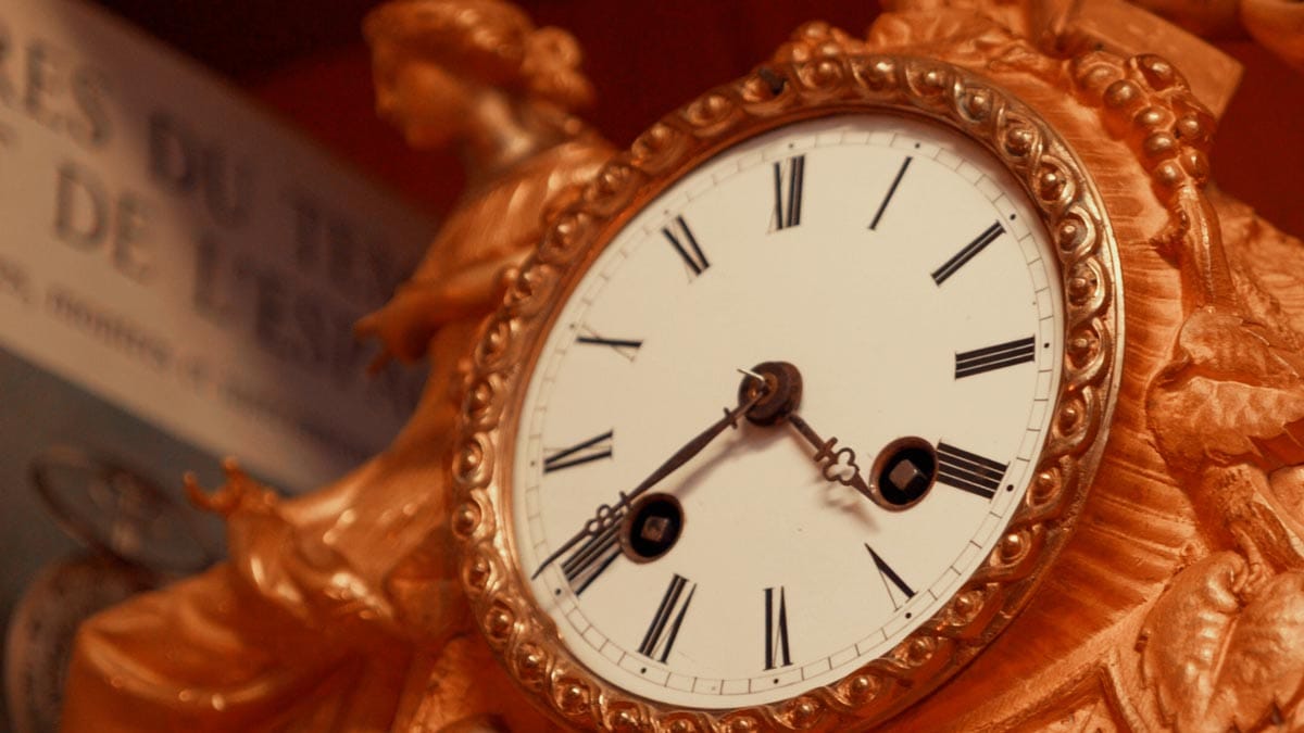 Gros plan sur une pendule décorative ancienne exposée au Musée horloger de Lorris dans le Loiret