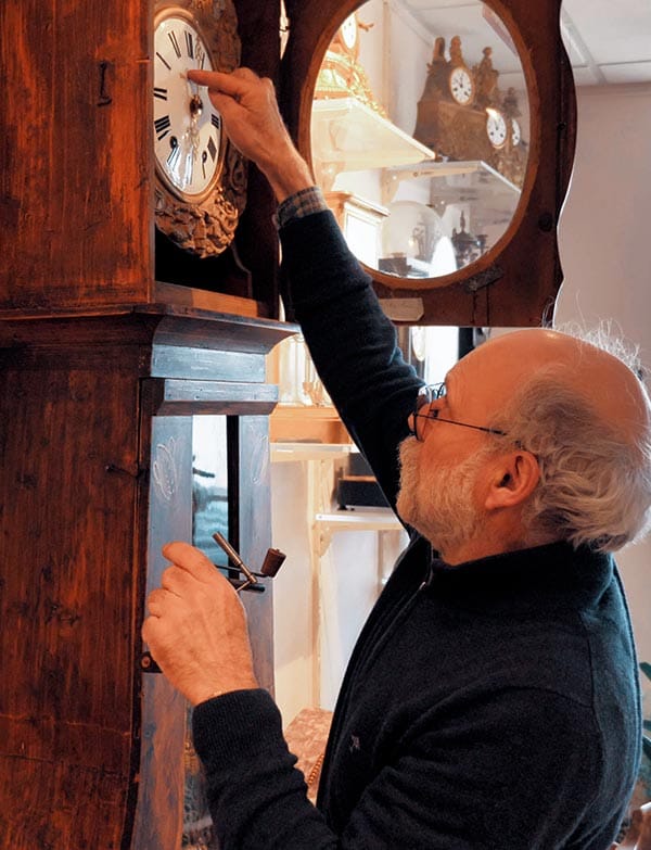 Horloger ajustant une horloge comtoise dans la salle d’exposition du musée horloger de Lorris